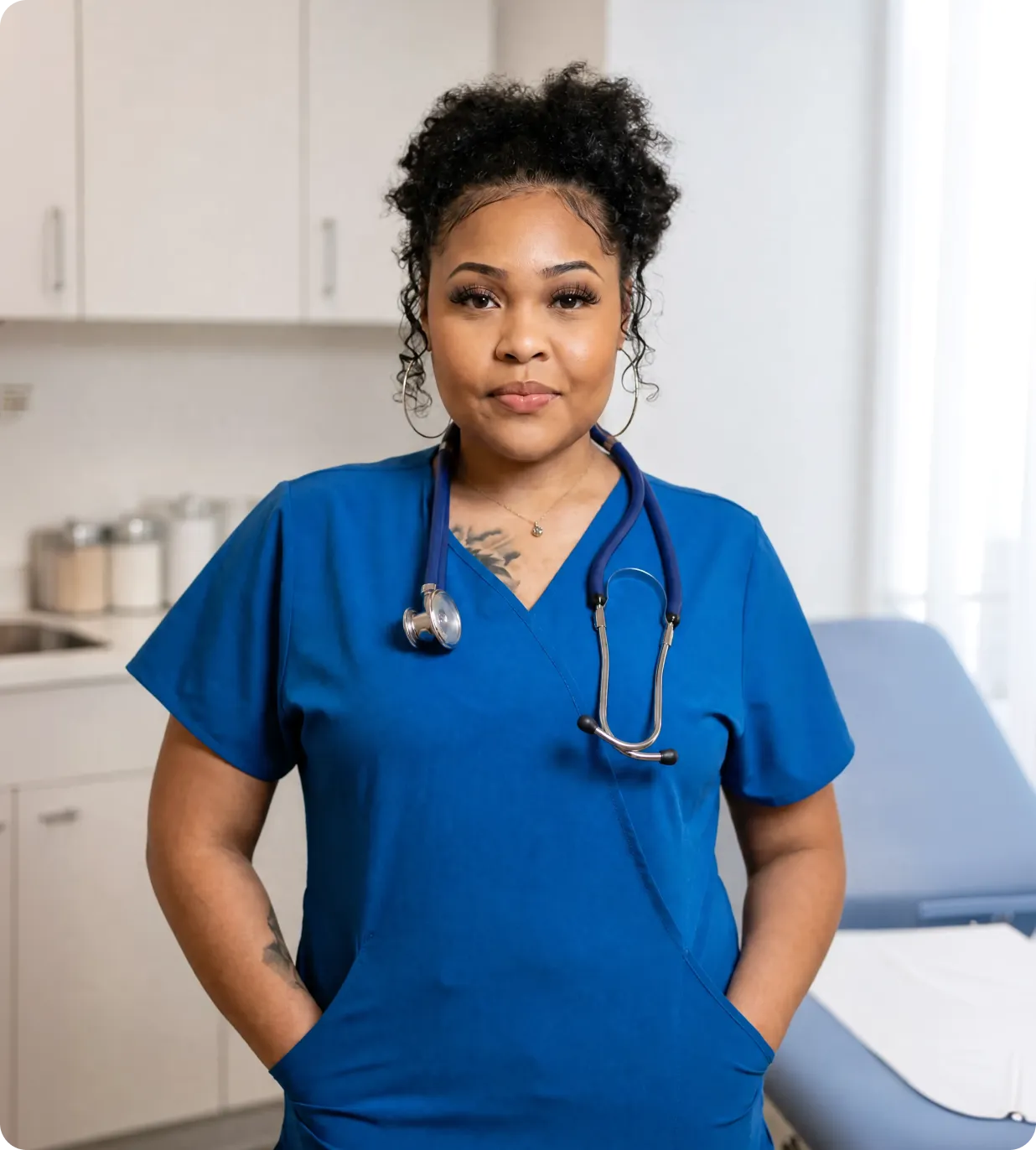 A respiratory therapist in blue scrubs standing in a clinical exam room