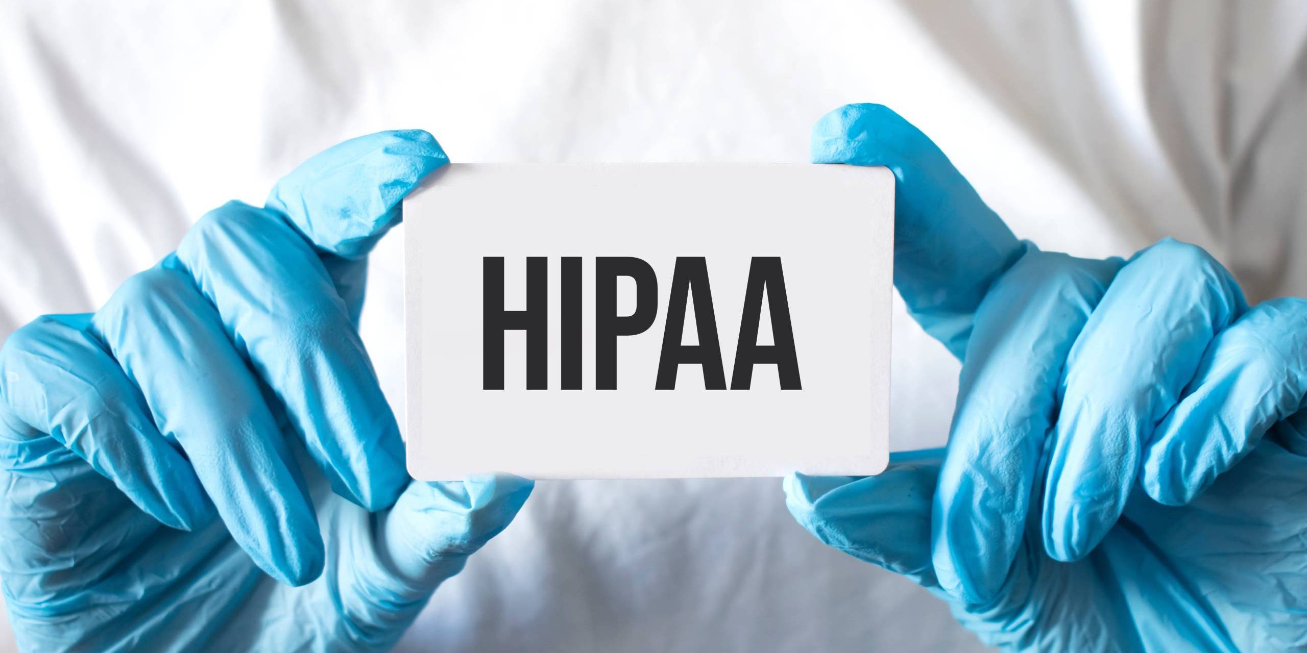 doctor hands holding white sign with HIPAA on it