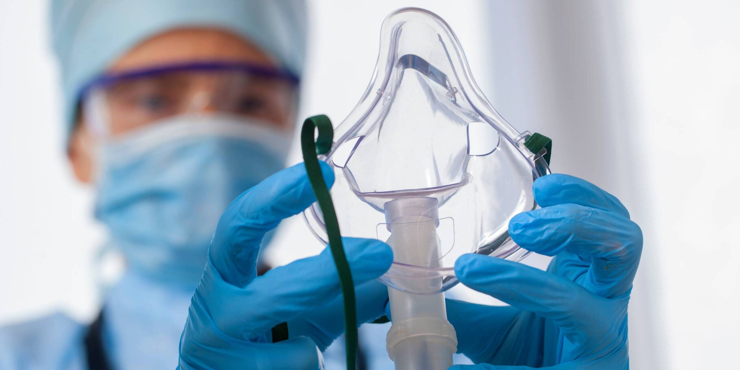 skills of a respiratory therapist A close up of a respiratory therapist with gloves on and is holding a respiratory mask