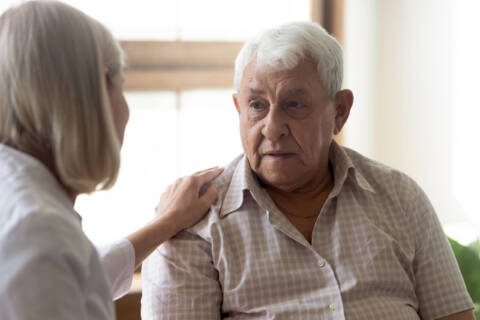 LPN Assisting Patient 70s man patient and licensed practical nurse communicating indoors