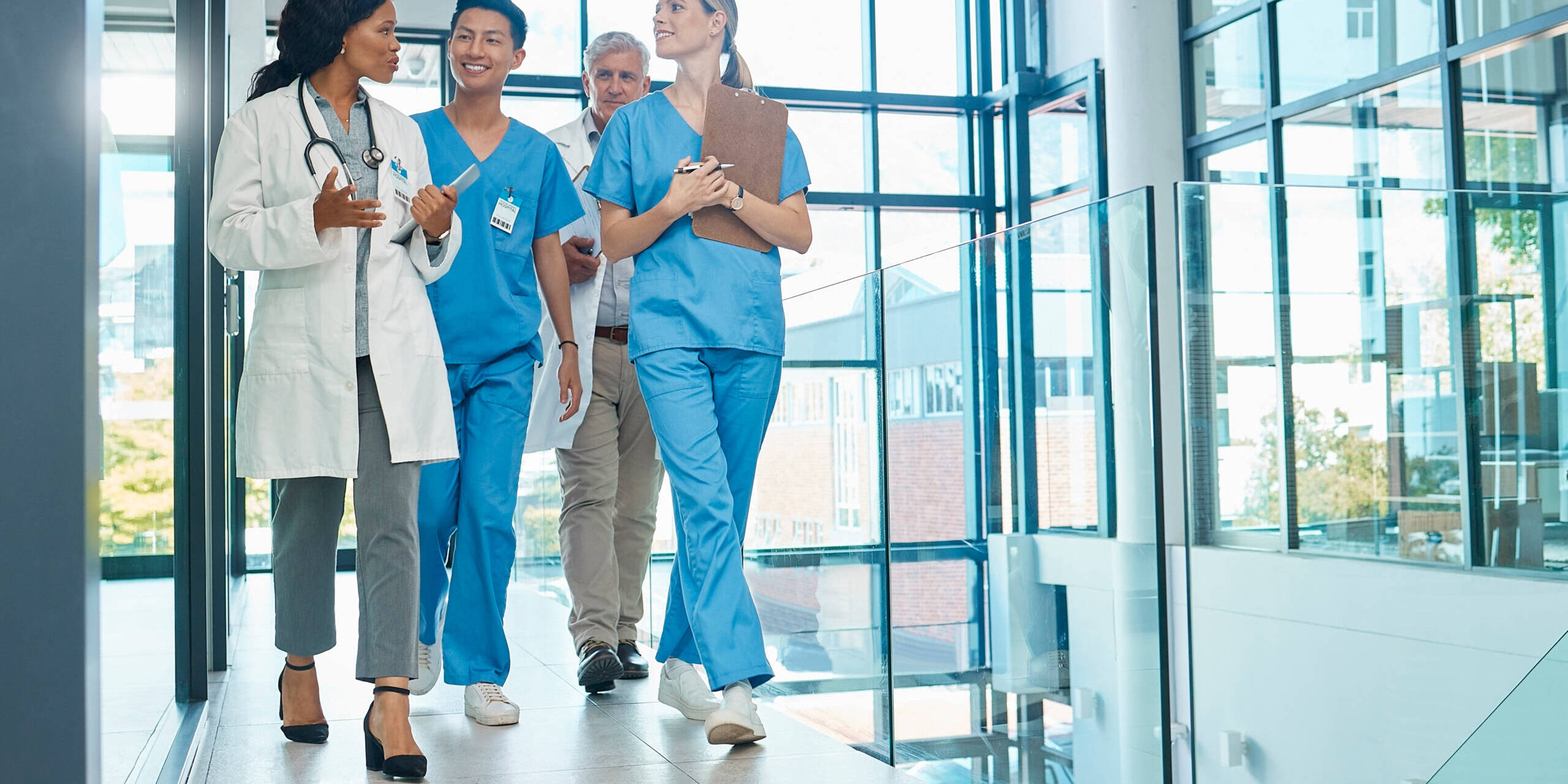 Healthcare, doctors and nurses walking together for discussion, planning or schedule. Diversity, men or women medical group talking about support strategy, medicine and surgery teamwork in hospital doc training nurses